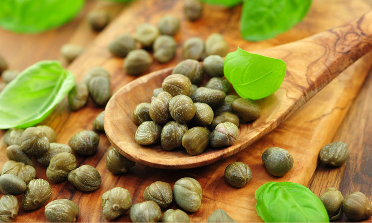 Capers on a wooden board.