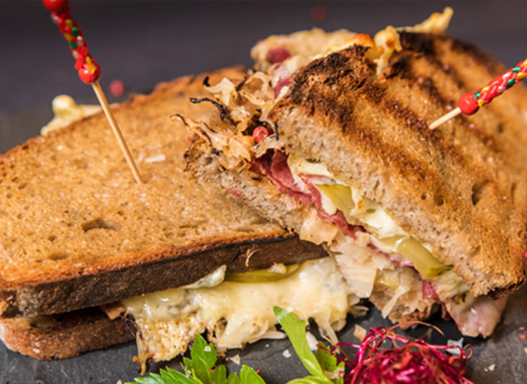 Two pieces of an american reuben sandwich.